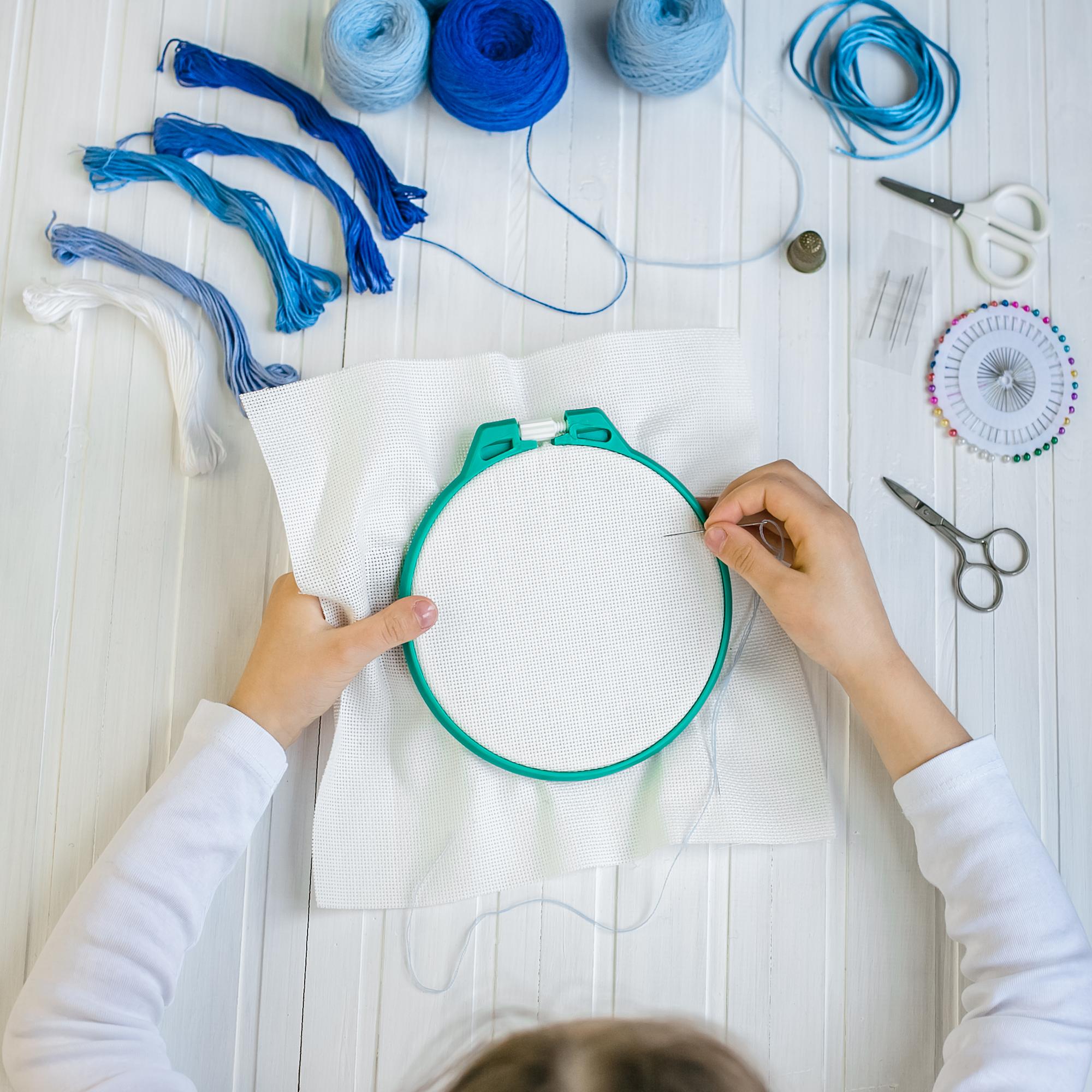 Instructor demonstrating hand embroidery on hoop